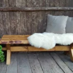 Klassisk kryssbänk från Nordanlids Rustik i massivt trä, där tappen sammanfogar kryssbenen och hålls fast med en kil. Okantad framsida där trädets naturliga form har sparats.