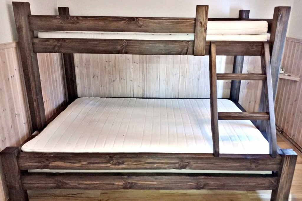 Handgjord våningssäng / familjesäng i massivt trä med en mörkbetsad finish, robust konstruktion och stege - tillverkad av Nordanlids Rustik i tidlös, lantlig stil.