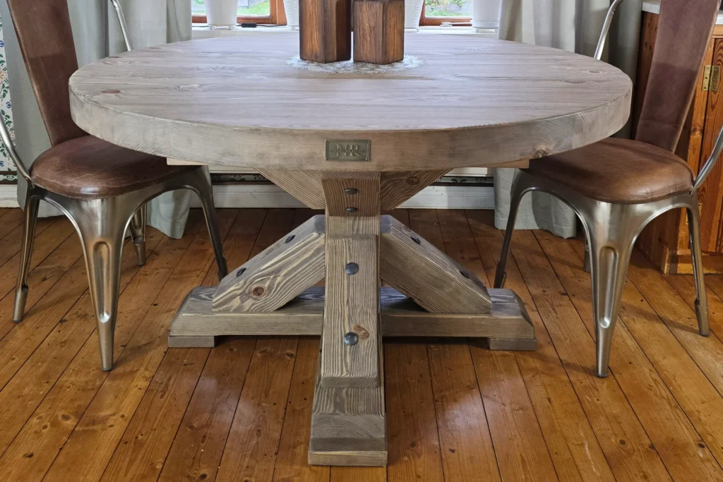 Handgjort runt matbord i massivt trä från Nordanlids Rustik. Ett matbord med attityd i lantlig och tidlös design. Svarta metallbeslag och en robust konstruktion som är tillverkat för att hålla i många generationer.